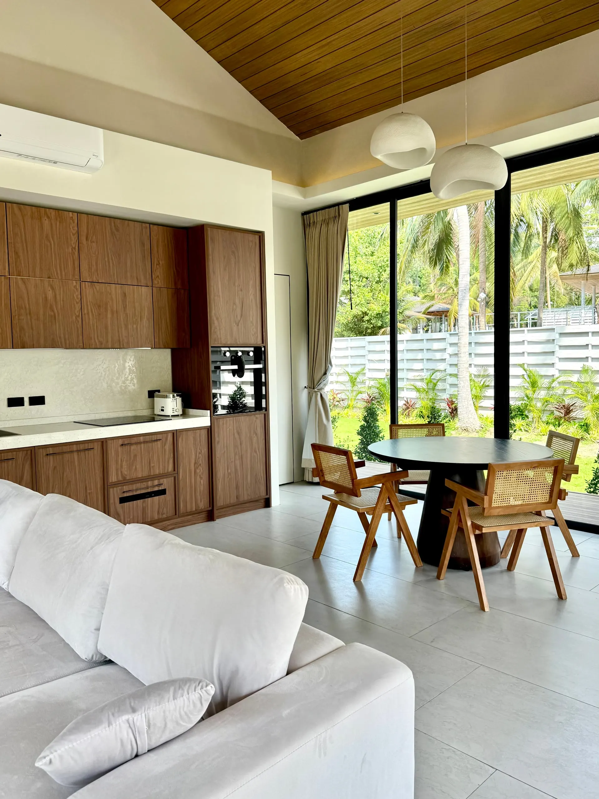 Villa I — open kitchen and dining under the slatted wood ceiling
