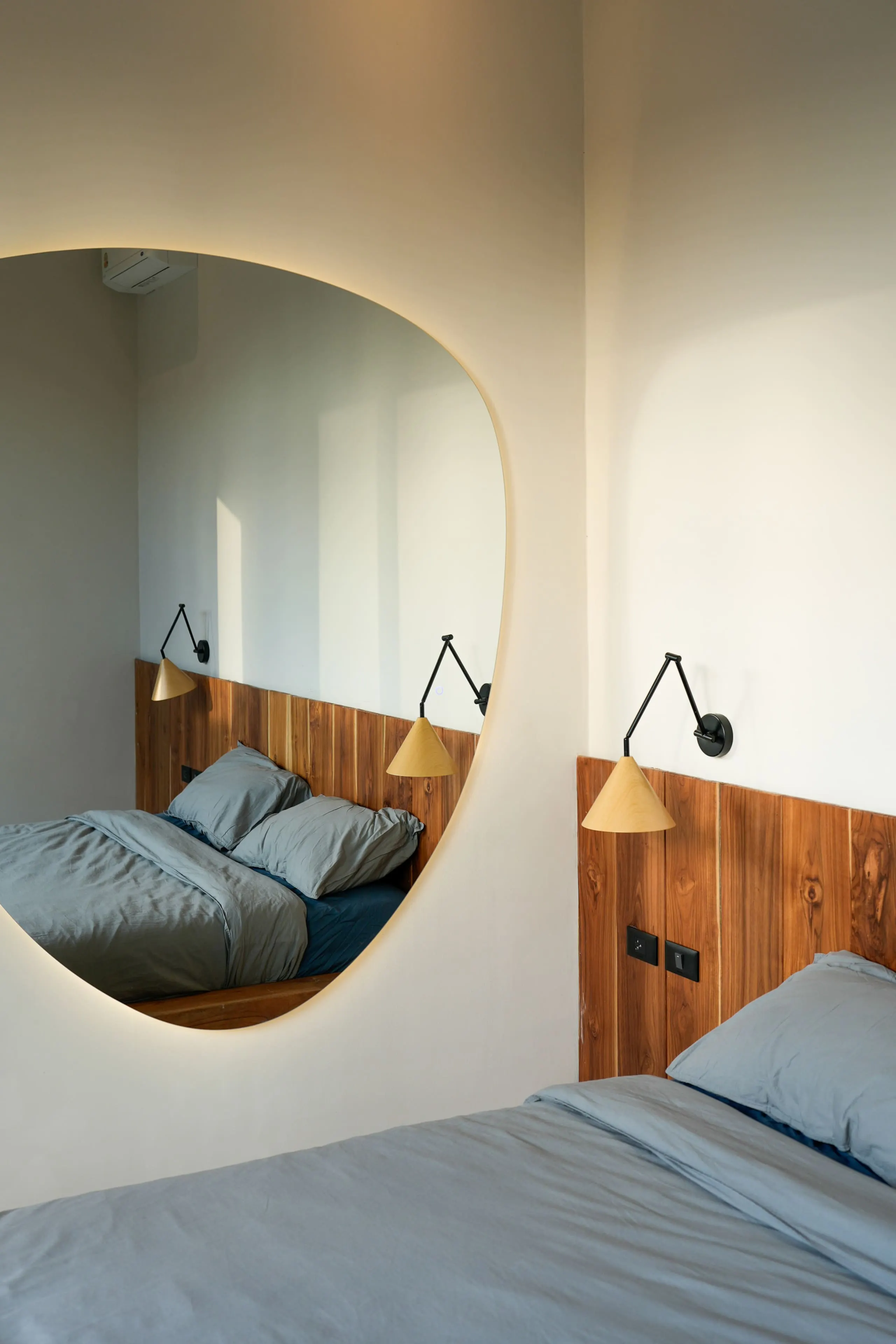 Villa II — bedroom one, backlit organic mirror and teak headboard wall