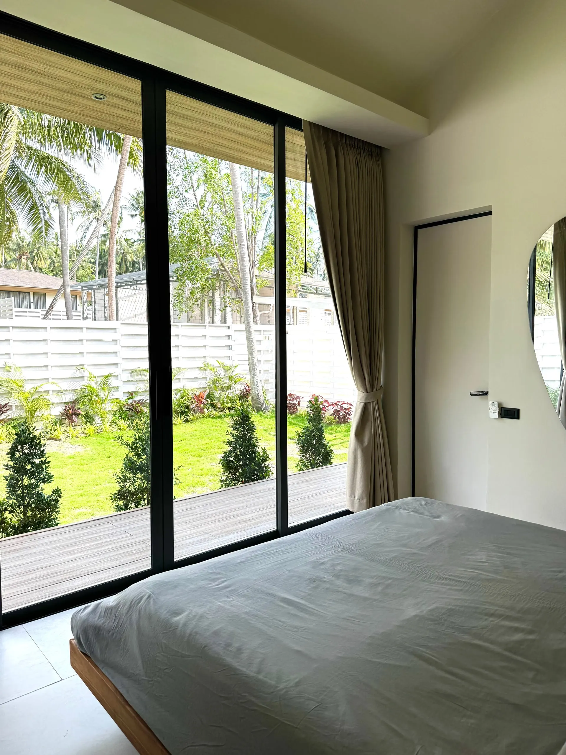 Villa I — bedroom one, bed by floor-to-ceiling glass onto the terrace