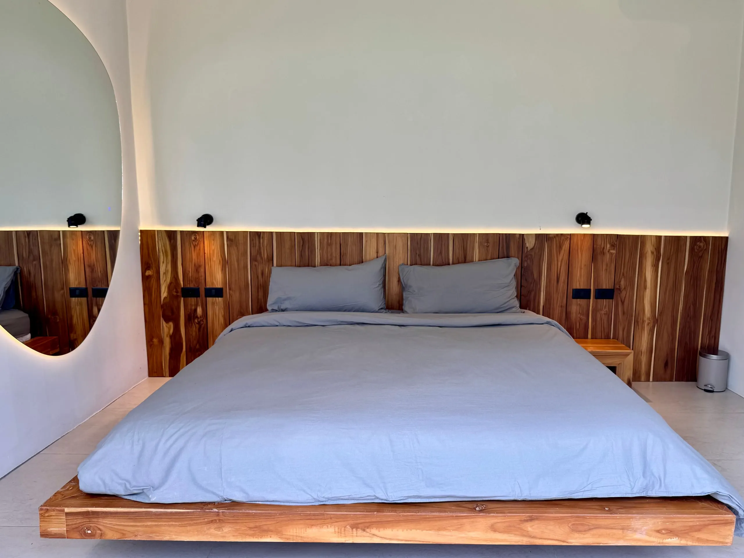 Villa I — bedroom one reflected in the curved wall mirror