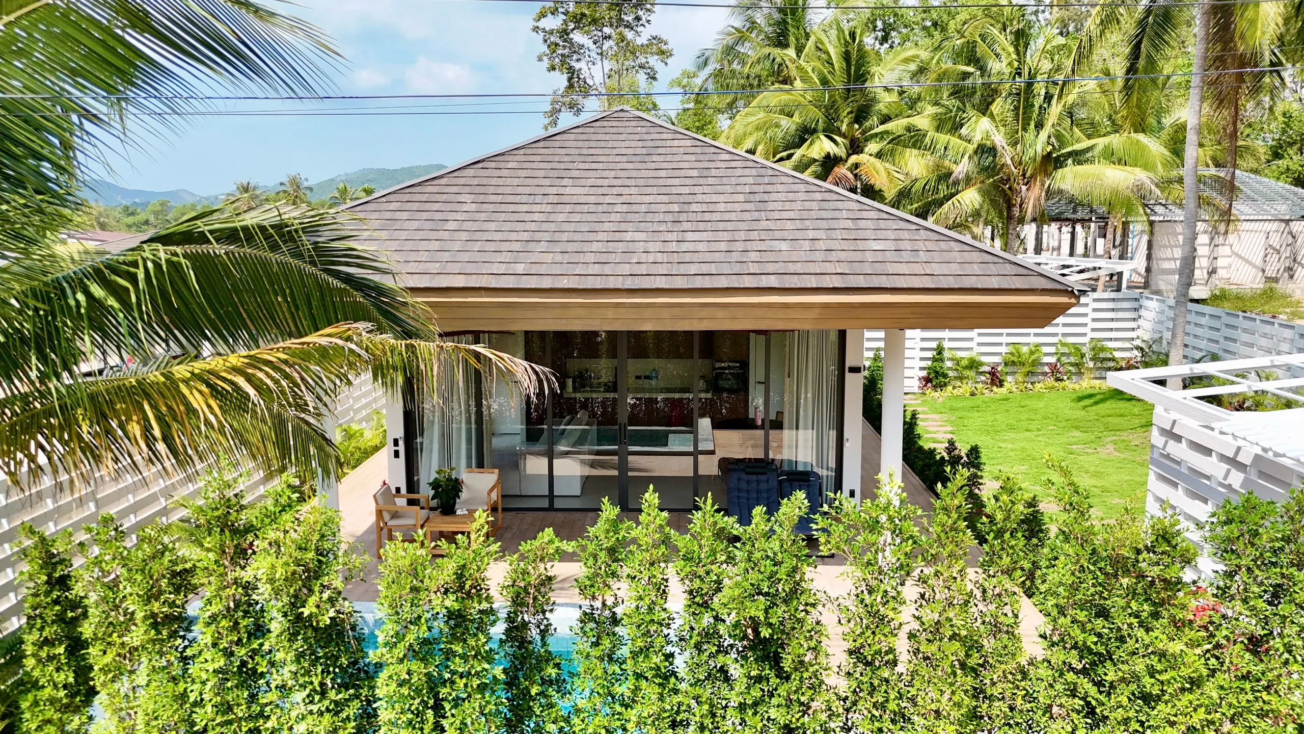White Lotus Villa I — private pool and wooden terrace beneath the grey shingle roof