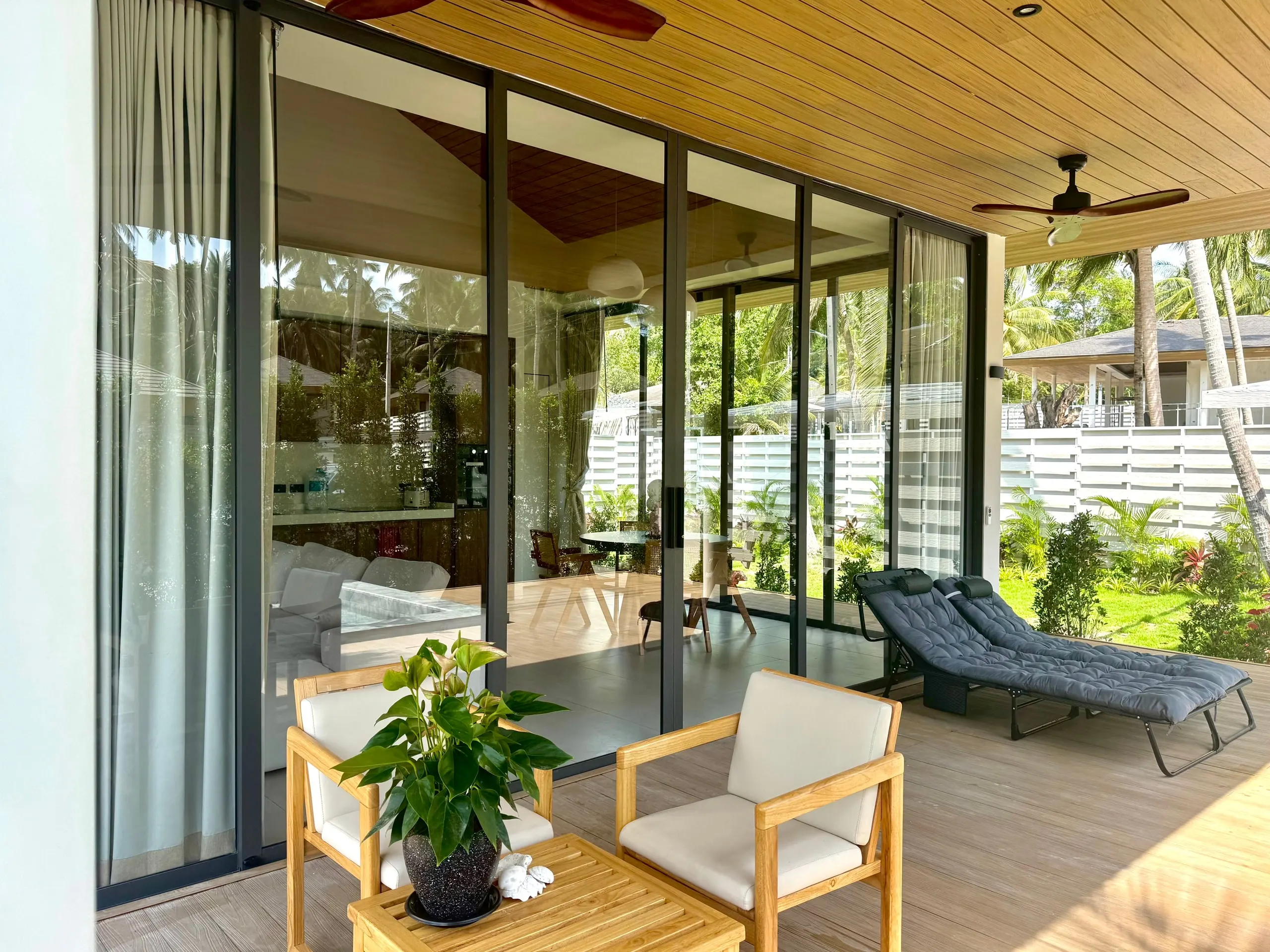 Villa I — covered terrace with ceiling fans and teak lounge chairs