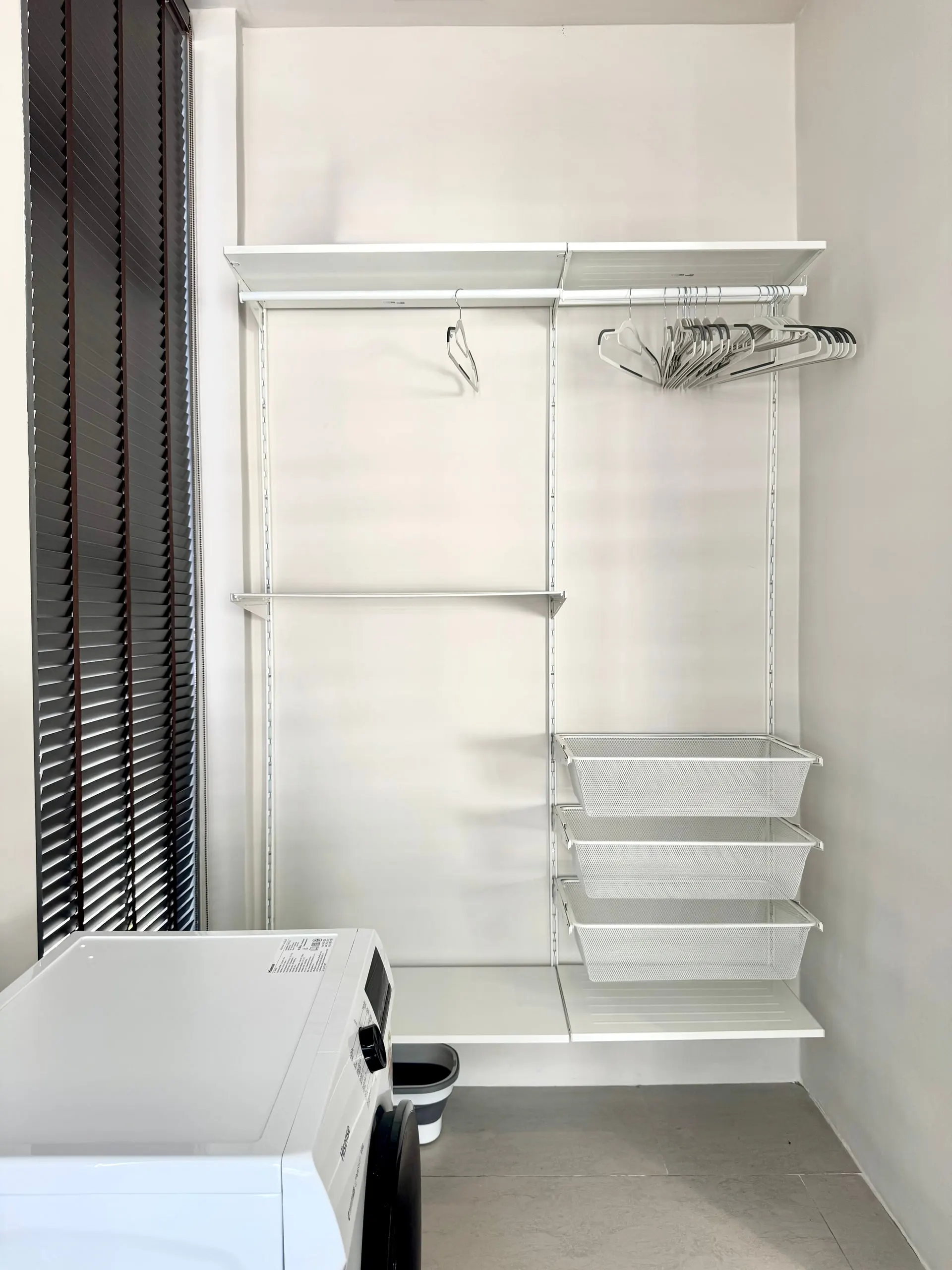 Villa II — laundry area with top-load washer and wardrobe system