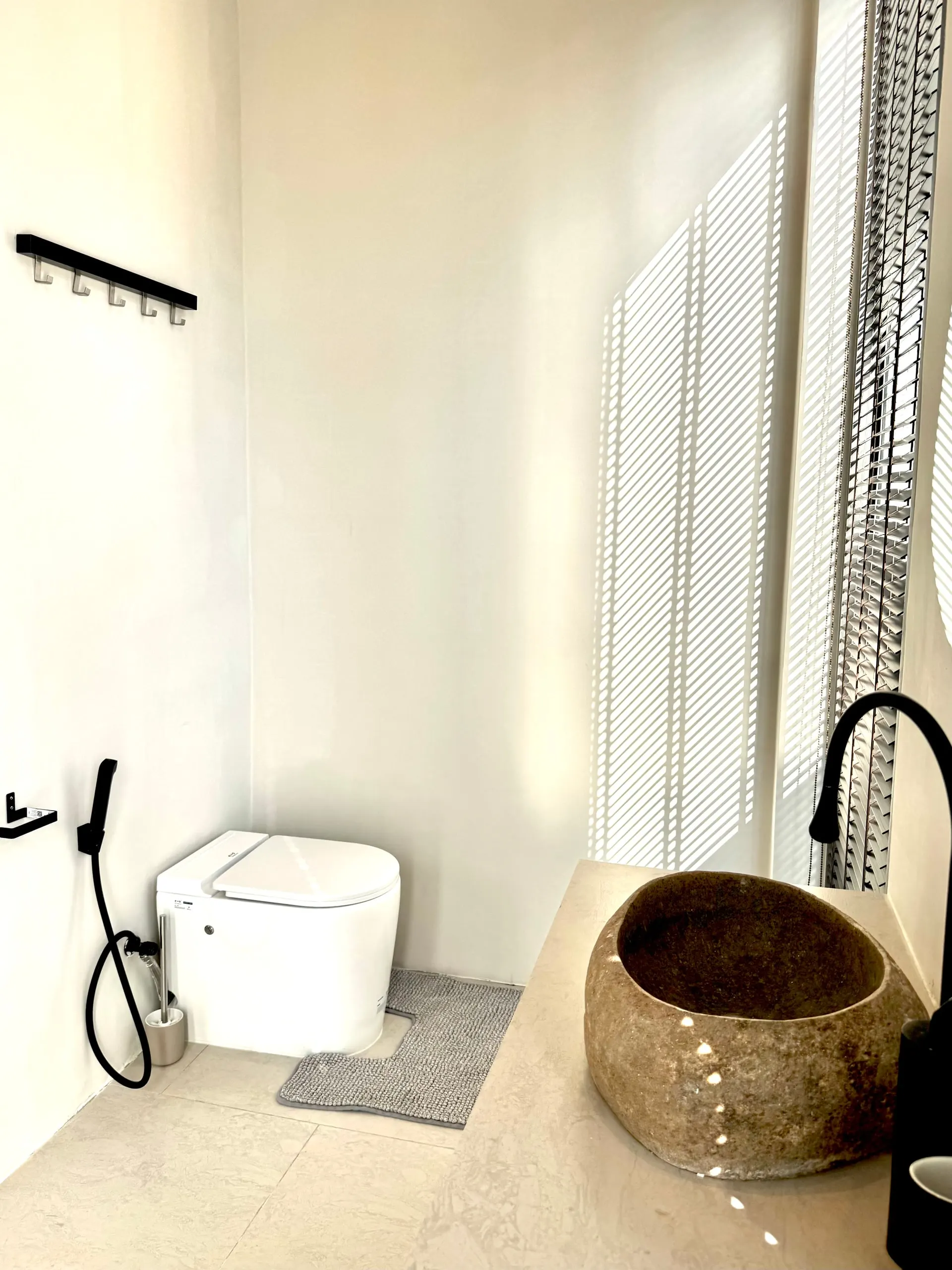 Villa II — guest toilet with bidet lid and stone basin