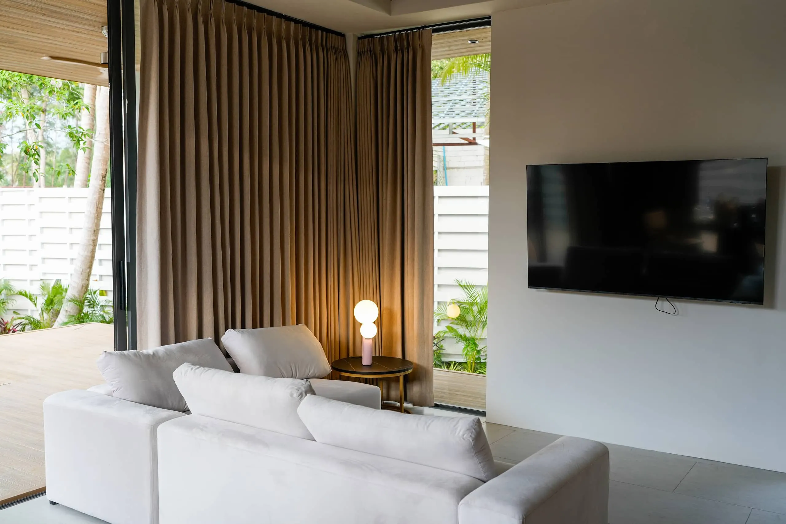 Villa II — living room, white modular sofa by corner glazing to the garden