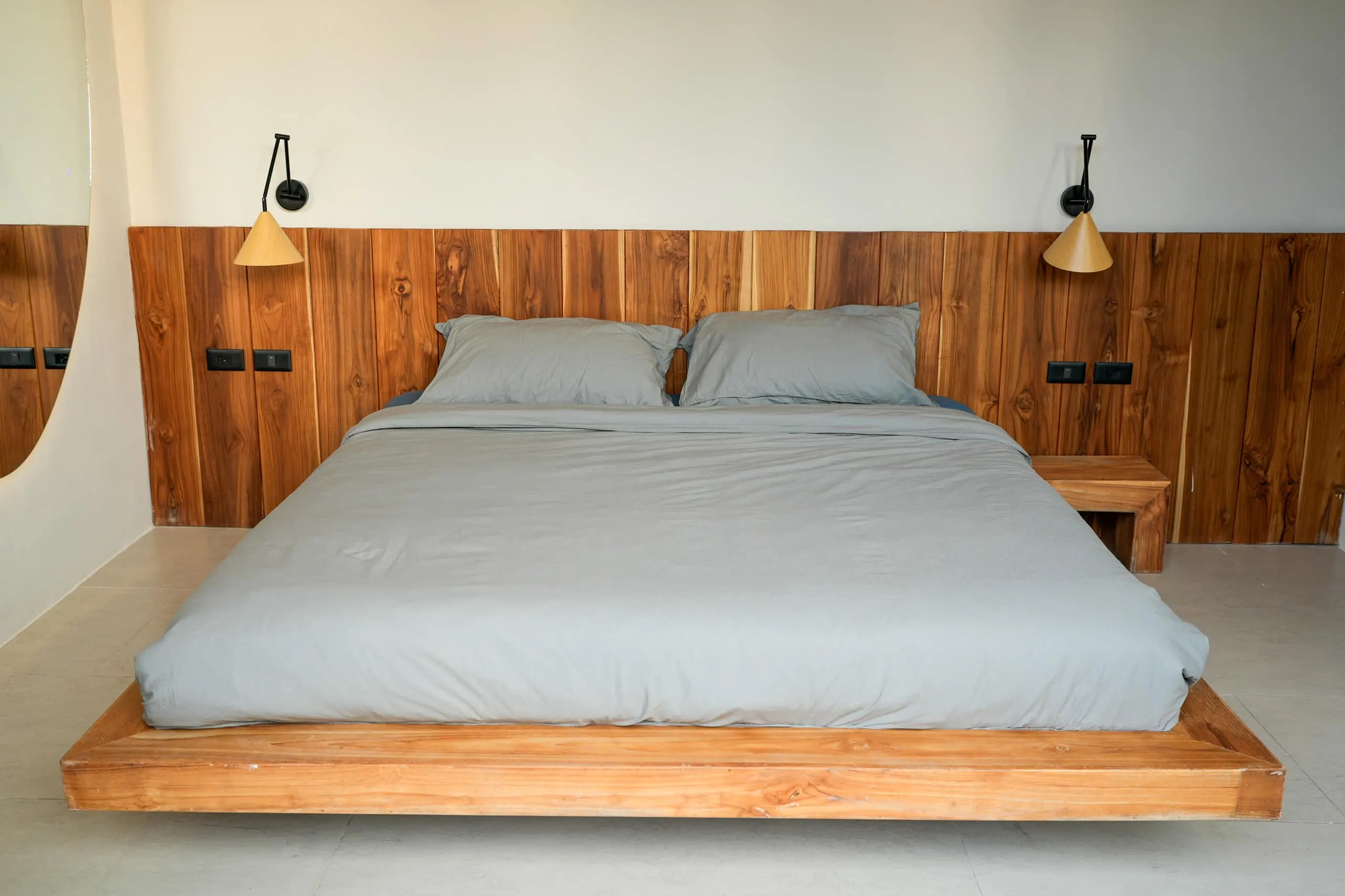 Villa II — bedroom two, teak bed with conical wall sconces